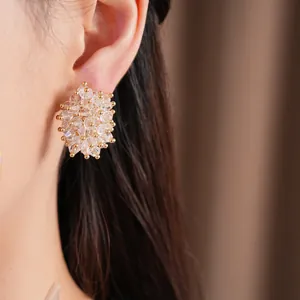 Detail shot of sparkling glass cluster stud earring worn on ear.