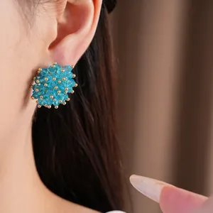 Detailed close-up of blue crystal cluster stud earrings worn elegantly on the ear lobe