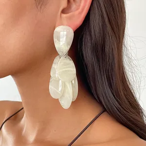 Close-up of retro resin swirled teardrop earrings with marble pattern on model