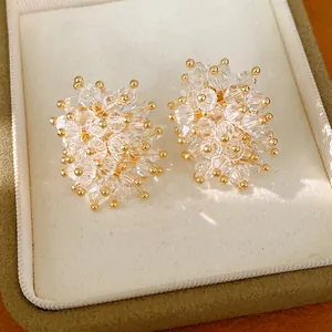 Detailed macro view of elegant floral glass crystal stud earrings with gold accents