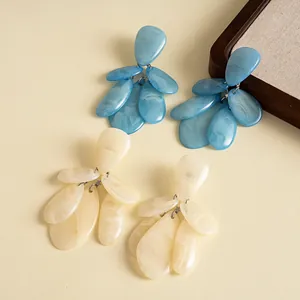 Detailed macro shot of retro marbled resin teardrop tassel earrings in blue and cream.