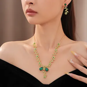 Primo piano di collana e orecchini vintage con fiori verdi indossati da una modella