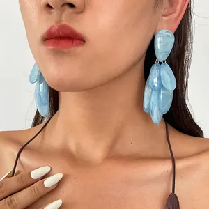 Detailed close-up showing blue marbled resin drop earrings worn by an Asian model