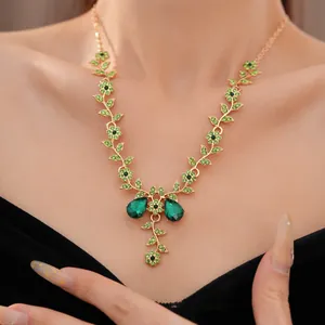 Primo piano del set collana vintage dorata con fiori e foglie di cristallo verde