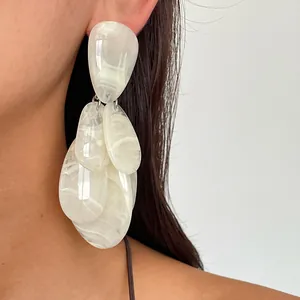 Macro detail of retro white marble resin water-drop tassel earrings shown on model