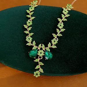 Dettaglio di collana dorata stile vintage con fiori e foglie di strass verdi lussuosi