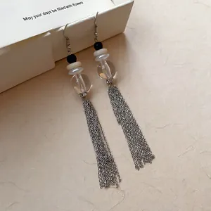 Gros plan d'élégantes boucles d'oreilles pendantes argentées avec perles