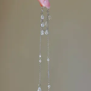 Gros plan de boucles d'oreilles à longs pompons en cristal avec chaînes en argent élégantes