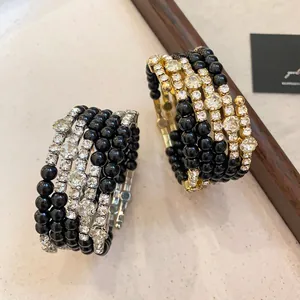 Detailopname van zwarte acryl wikkelarmbanden met schitterende strass-stenen