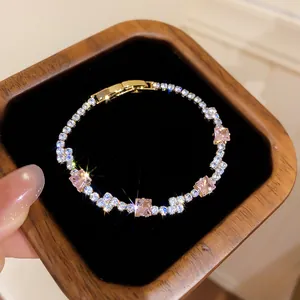 Detailansicht eines funkelnden Armbands mit rosa und klarem Zirkonia in einer Holzbox.