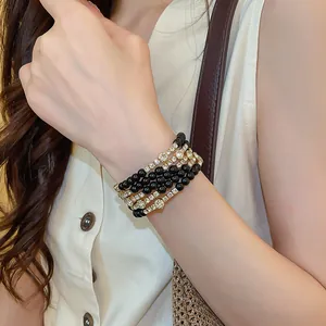 Close-up van een elegante meerlaagse armband met zwarte kralen en strass-steentjes