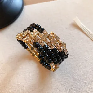 Detailopname van luxe meerlaagse open armband met zwarte kralen en fonkelende strass-stenen