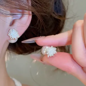Primo piano di orecchini di perle di lusso con design geometrico a stella in zircone