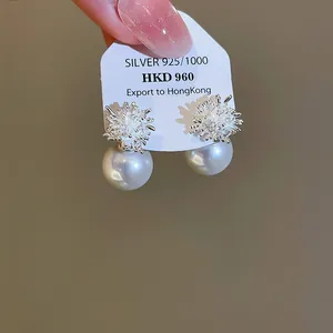 Dettaglio di orecchini a lobo francesi in zircone e perla su scheda espositiva