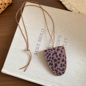 Nahaufnahme einer Brillenhalter-Halskette mit Leopardenmuster auf einem Buch