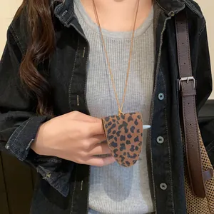 Detailaufnahme einer Brillenhalter-Halskette mit Leopardenmuster zu einer Jeansjacke