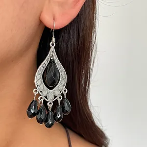 Detailed macro view of black faceted teardrop beads and ornate silver-toned metal frame