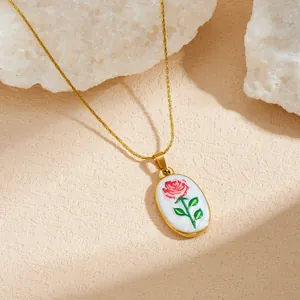 Vue détaillée du pendentif rose en émail sur une chaîne serpent plaquée or élégante.