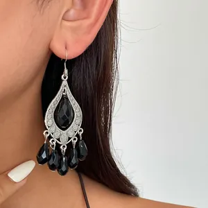 Close-up detail of vintage silver water drop earrings featuring elegant black faceted tassels