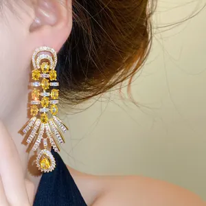 Vintage Hofstil Goldene Hängeohrringe mit gelben und klaren Zirkonen am Modell