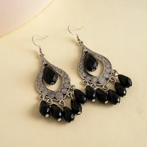 Close-up of gothic style black acrylic waterdrop tassel earrings with silver filigree