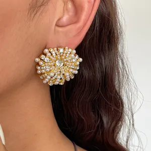 Vue rapprochée d'élégantes boucles d'oreilles fleurs avec perles et strass brillants