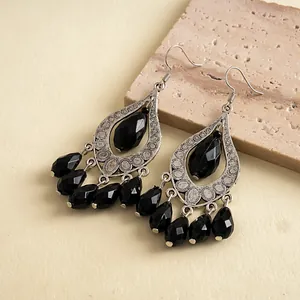 Close-up detail of black acrylic waterdrop tassel earrings with vintage silver finish.