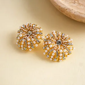 Détail de boucles d'oreilles fleur de luxe avec perles et strass scintillants