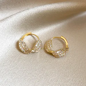 Close-up detail showing the twisted design and pavé zircon of 14k gold plated earrings.