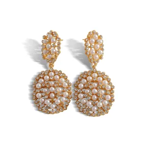Boucles d'oreilles pendantes ovales évidées dorées avec perles blanches et strass brillants