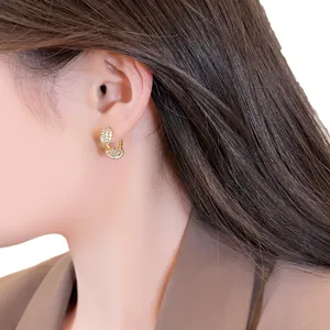 Elegant 14k gold plated twisted hoop earrings with sparkling zircons shown on model's ear