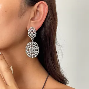Gros plan détaillé des boucles d'oreilles pendantes avec strass et perles sur le modèle