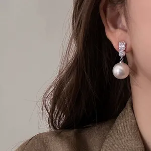 Elegant French style drop earrings featuring shimmering crystals and a large white pearl.