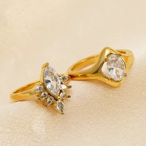 Gros plan d'élégantes bagues en acier doré serties de zircons brillants de taille marquise