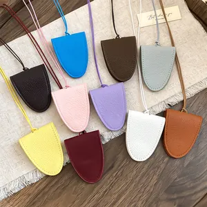 Verschillende kleuren draagbare lederen brillenhouder hangers op linnen doek.