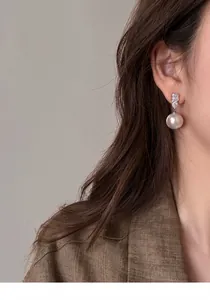 Elegant French style pearl drop earring with sparkling stones worn by a female model