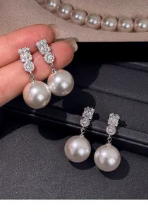 Detailed view of elegant French style pearl drop earrings with sparkling zirconia stones