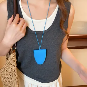 Detailweergave van een blauwe lederen brilhouder ketting gedragen door een model.