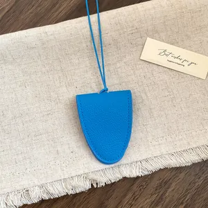 Detailweergave van een helderblauwe lederen brillenhouder met een kiezeltextuur.