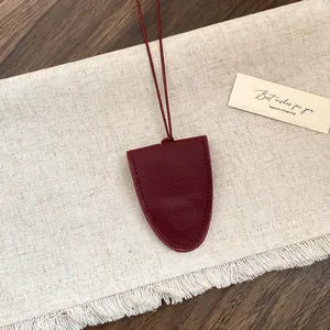 Detail van bordeauxrode lederen draagbare brillenhouder ketting met stiksel