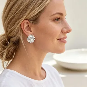 Femme élégante portant des boucles d'oreilles soleil vintage en argent dans un cadre naturel.