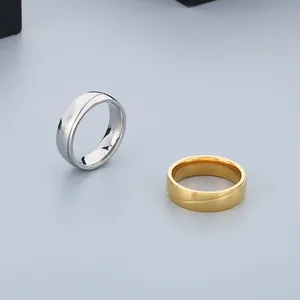 Detailansicht minimalistischer Titanstahlringe in Silber und Gold mit geschwungener Linie