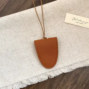 Detailopname van een bruine leren brillenclipketting met zeer fijne stiksels