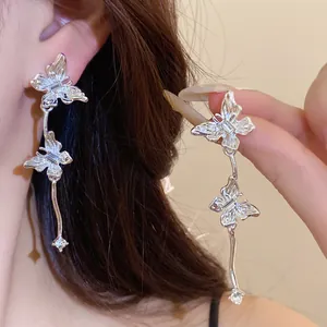 Macrodetail van elegante zilveren vlinderkwastoorbellen met ingelegde strassteentjes