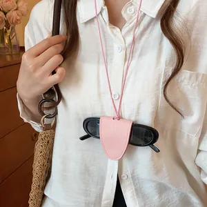 Detailopname van een roze lederen brillenhouder ketting gedragen op een wit overhemd