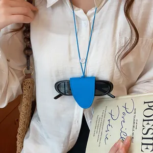 Detail van een blauwe leren brillenhouder hanger gedragen als een stijlvolle modeketting.