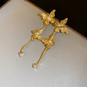 Gedetailleerde close-up van elegante gouden vlinder oorbellen met fonkelende strass steentjes