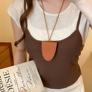Detailweergave van de bruine lederen hanger ketting als brillenhouder op een model