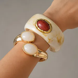 Vue détaillée du jonc rétro en résine marbrée et du bracelet manchette doré au poignet
