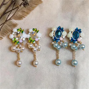 Elegant vintage floral pearl stud earrings with crystal accents in blue and white colors.